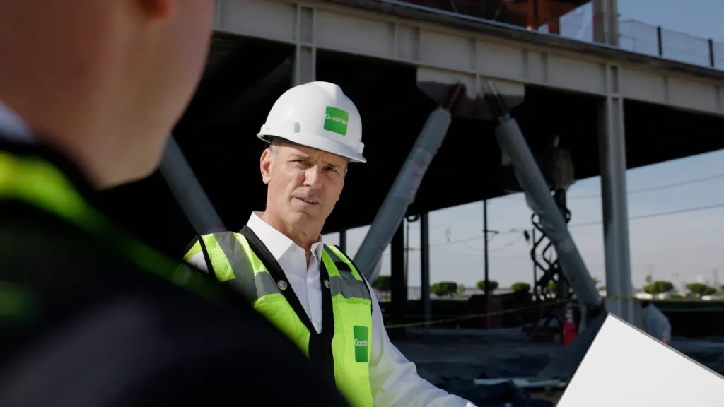 A Goodman executive in a hard hat and hi-vis vest on a construction site