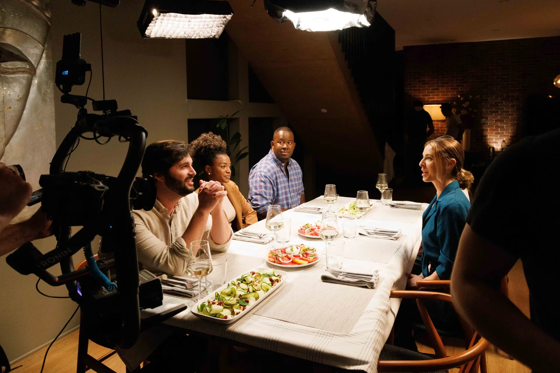 Friends laughing over dinner on a Nomadic Creations restaurant shoot